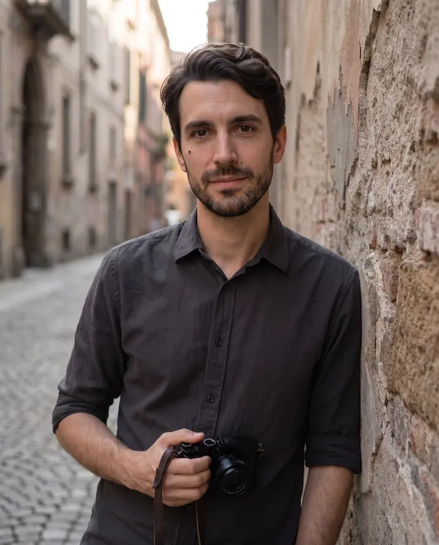 Louis Marchetti in un vicolo del centro storico di Napoli, appoggiato a un muro di tufo, con una fotocamera mirrorless in mano