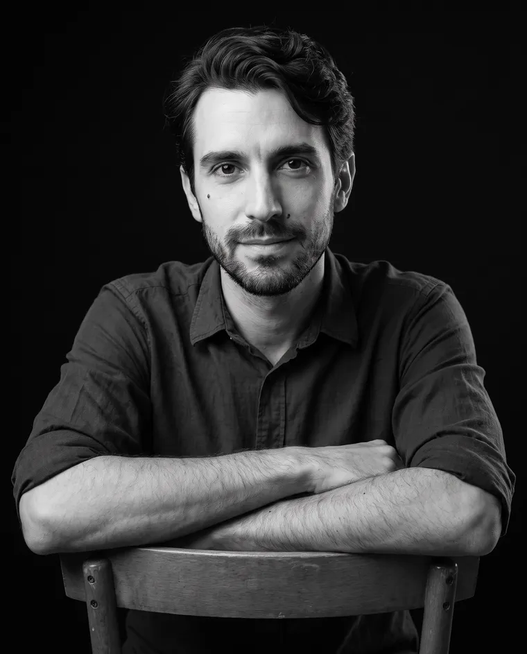 Ritratto in bianco e nero di Louis Marchetti appoggiato allo schienale di una sedia